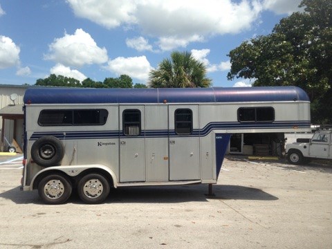 (Still Needs to be Serviced) 1997 Kingston (2) horse straight load with a tack room that has saddle racks and bridle hooks.  The horse area has an interior height of 7’6” tall x 7’ wide x 14’ long,  (2) full size escape doors, large sliding bus windows along the sides of each horse, roof vents, removable dividers, rubber lined walls, rubber mats over wood floor and a rear ramp with dutch doors!  Spare tire. 